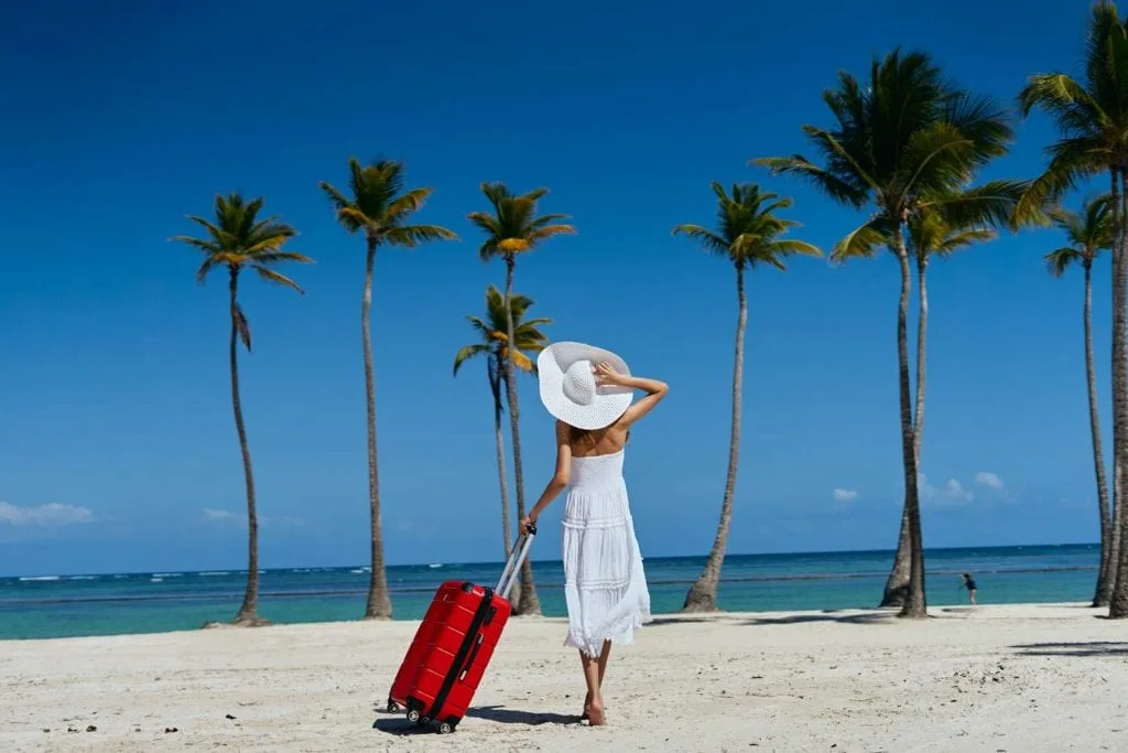 woman on a beach with a suitcase 1024x683