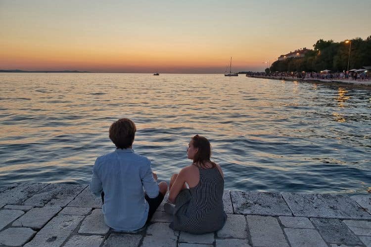 A couple watching the sunset in Zadar Croatia