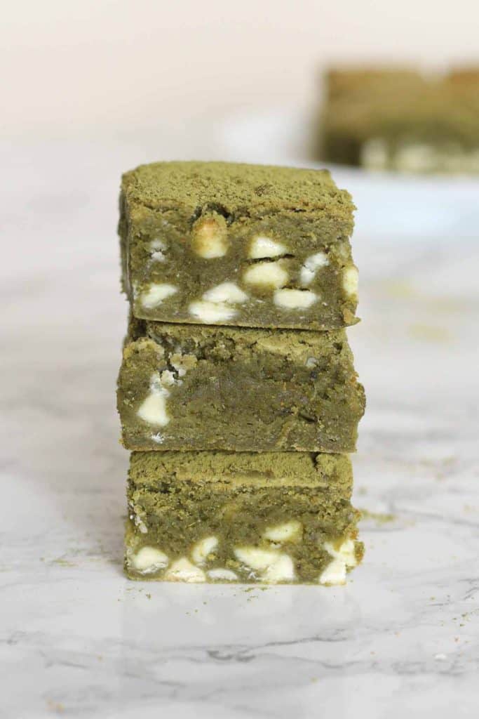 A stack of three white chocolate green tea brownies, showing a green tea-flavored batter with white chocolate chunks. A delicious Asian Dessert Recipe!